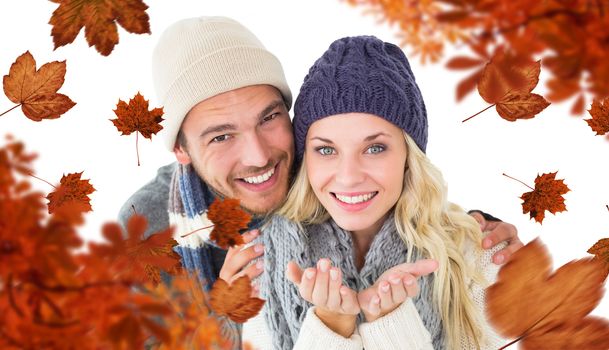 Composite image of attractive couple in winter fashion smiling at camera