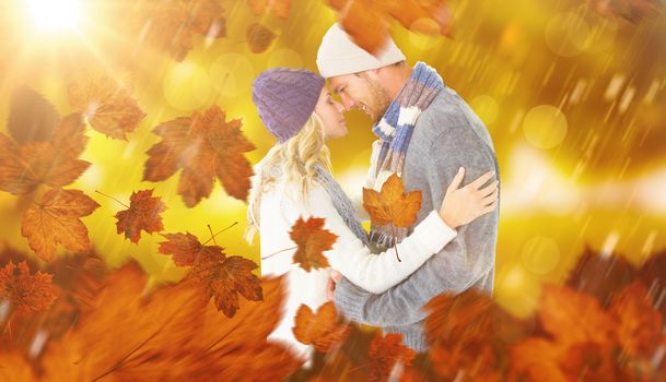 Composite image of attractive couple in winter fashion hugging