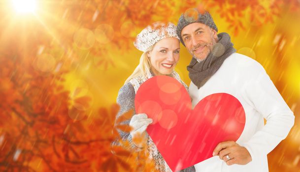 Composite image of portrait of happy couple holding heart