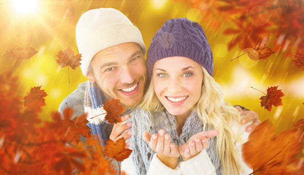 Composite image of attractive couple in winter fashion smiling at camera