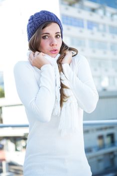 Cold brunette in warm clothes looking at camera 