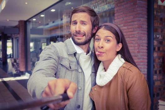 Young happy couple taking a selfie while making weird faces