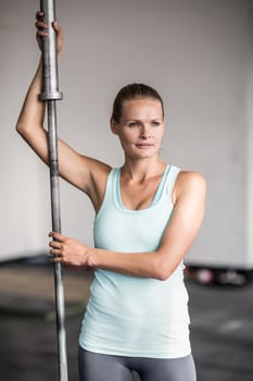 Portrait of beautiful fit woman holding barbell
