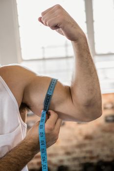 Man measuring biceps with tape