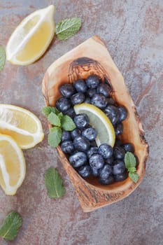 Fresh Blueberries and lemon slice on table, vintage style. Macro, selective focus. Natural light