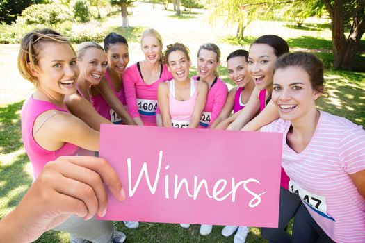 Winners against smiling women running for breast cancer awareness