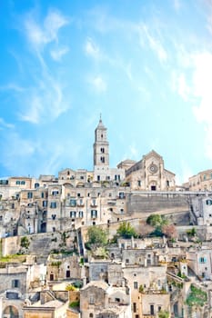 panoramic view of tipical stones and church of Matera under blue sky