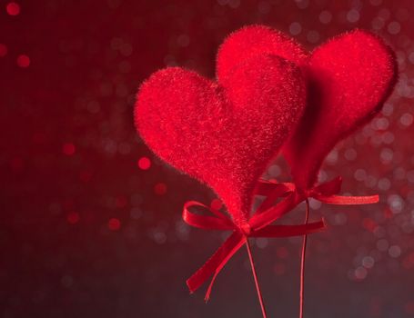 two red velvet hearts on red tint light bokeh background with space for text, concept of valentine day 