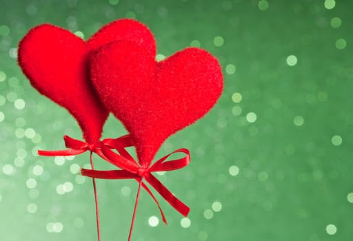 two red velvet hearts on green tint light bokeh background with space for text, concept of valentine day 