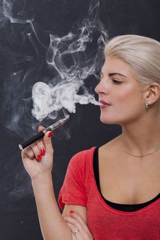 Stylish blond woman smoking an e-cigarette
