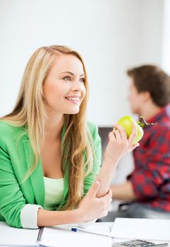 student girl with green apple in college