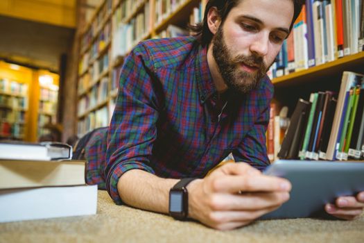Student studying on floor in library wearing smart watch