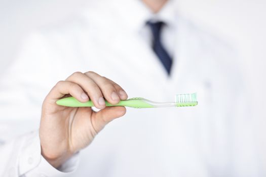 dentist or stomatologist holding toothbrush