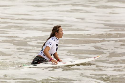 Surfer races the Quicksilver & Roxy Pro World Title Event