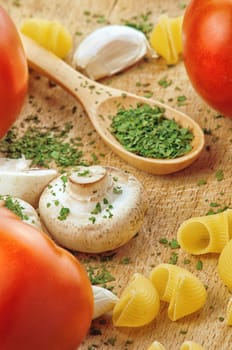 Garlic Parsley Mushroom tomato Pasta Recipes on wooden board in the kitchen. Food preparation background.