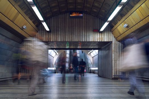 fast moving people at subway train station, long exposure image