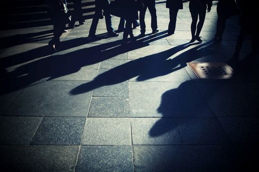 Shadows of people on the pavement