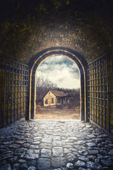 Gate opening to road leading to an old abandoned house