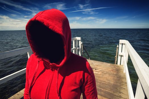 Faceless Hooded Unrecognizable Woman at Ocean Pier