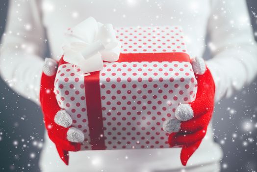 Woman offering Christmas gift in wrapped box