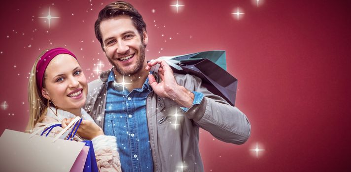 Composite image of smiling couple with shopping bags 