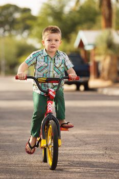 Single boy riding bicycle on street