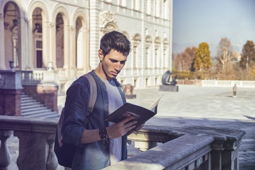 Young Man Holding a Guide Outside Historic Building