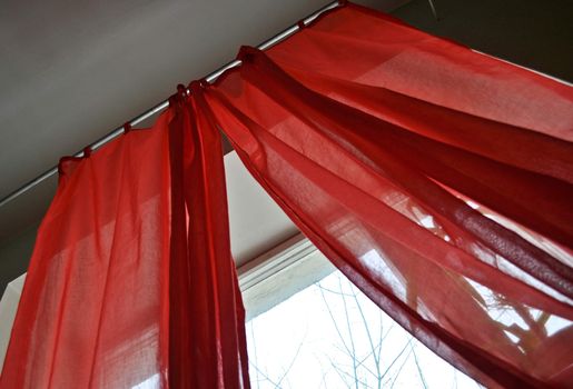 Red curtains before a window