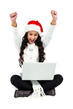 Woman sitting on the floor rejoicing looking at laptop