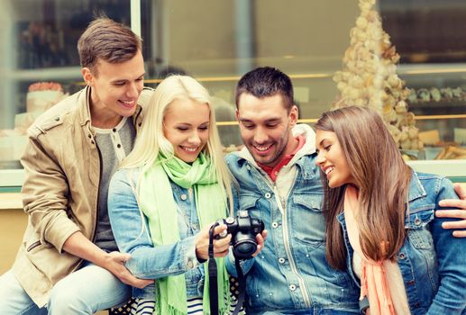 group of smiling friends with digital photocamera