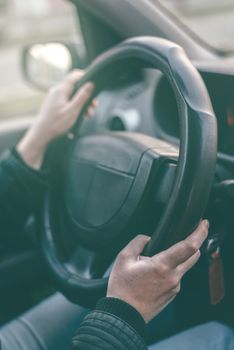 Female driver hands griping steering wheel