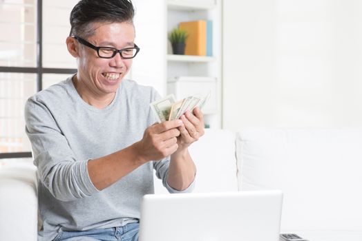 Mature Asian man counting money