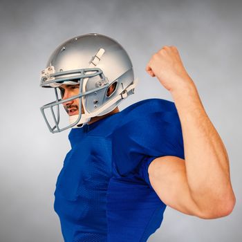 Composite image of american football player looking away while flexing muscles