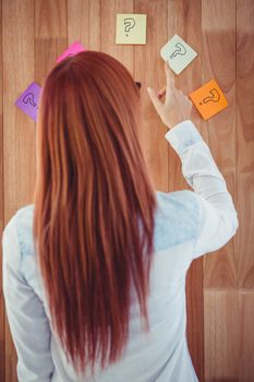 Rear view of hipster woman looking post-it