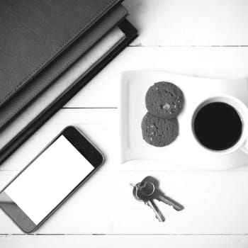 coffee cup with cookie,phone,stack of book and key black and whi