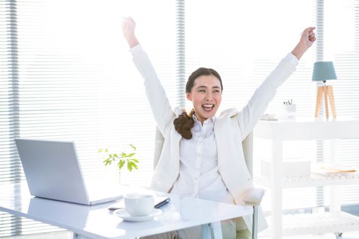 Businesswoman rejoicing with arms outstretched