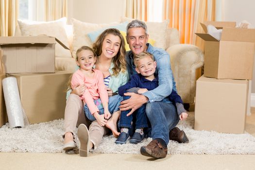 Portrait of smiling family sitting on the carpet