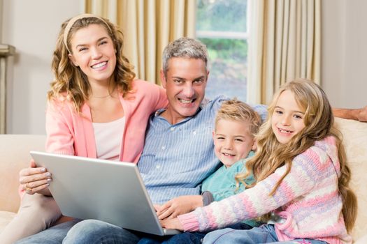 Happy family using laptop on the sofa