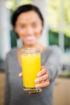 Smiling brunette holding glass of orange juice