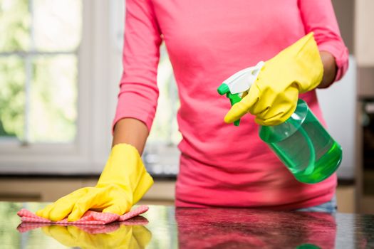 Midsection of woman cleaning the counter