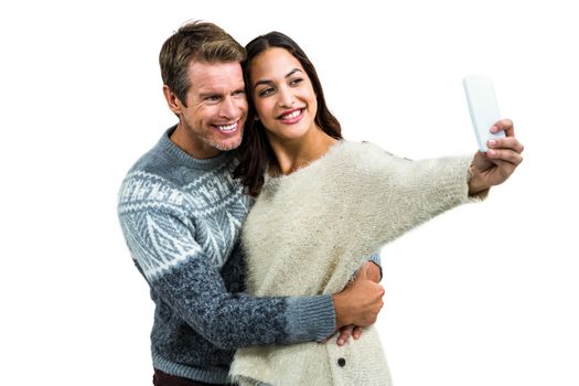 Happy couple wearing warm clothing taking selfie