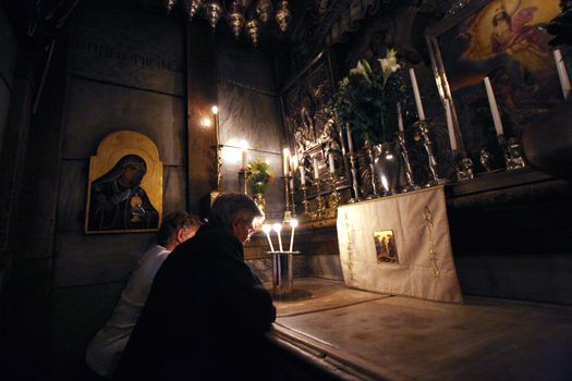 Pilgrims pray at the tomb of Jesus in the Church of the Holy Sepulchre in Jerusalem