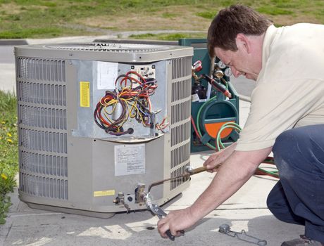 Repairman Working On Air Conditioning Unit