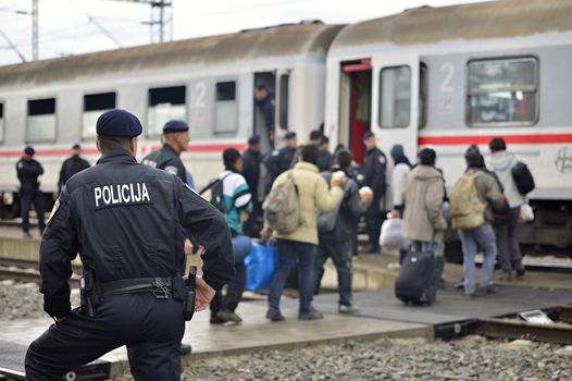 October 5, 2015; Tovarnik in Croatia. Croatian police assist refugees get into train which will go to Hungary.