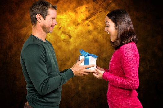 Composite image of excited girlfriend taking gift from boyfriend 