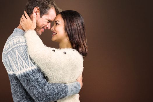 Composite image of cheerful couple in warm clothing embracing each other