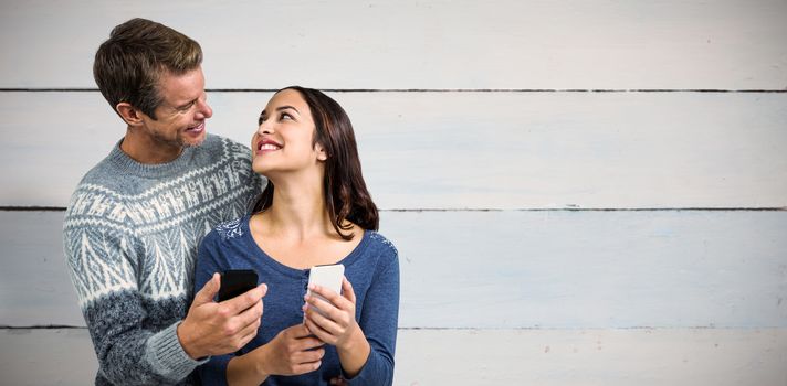 Composite image of happy romantic couple with mobile phone