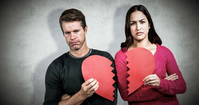 Composite image of portrait of serious couple holding cracked heart shape 