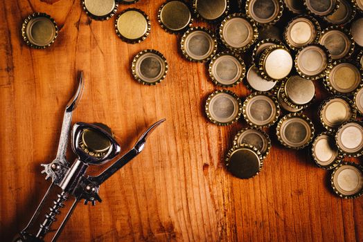 Classic bottle opener and pile of beer bottle caps