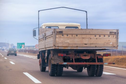 Old trailer truck in motion on freeway